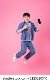 Young Asian Man Jumping On Blue Background