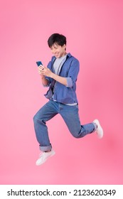 Young Asian Man Jumping On Blue Background