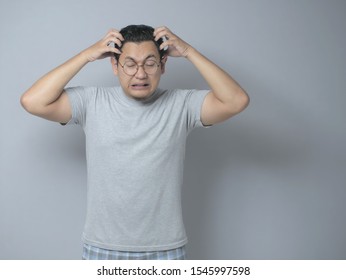 Young Asian man looked frustrated having a headache, stress expression. Close up portrait against grey background - Shutterstock ID 1545997598
