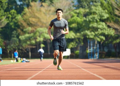 Young Asian Man Male Athlete Running Training Exercising On Track.