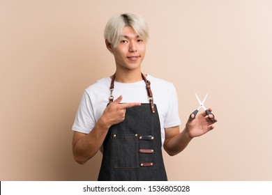 Young Asian Man Over Isolated Background With Hairdresser Or Barber Dress And Pointing It