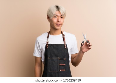 Young Asian Man Over Isolated Background With Hairdresser Or Barber Dress