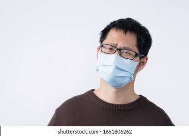 Young Asian Man Portrait, Feeling Sick, Wearing A Surgical Blue Face Mask To Prevent Infection, Air Pollution Isolated On White Background, Cut Out.