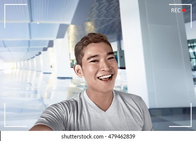 Young Asian Man Pose Selfie In Airport Lobby Alone, Smile Expression And Cheerful