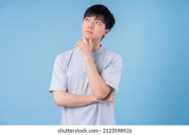 Young Asian man posing on blue background - Shutterstock ID 2123598926