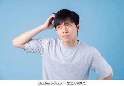 Young Asian man posing on blue background