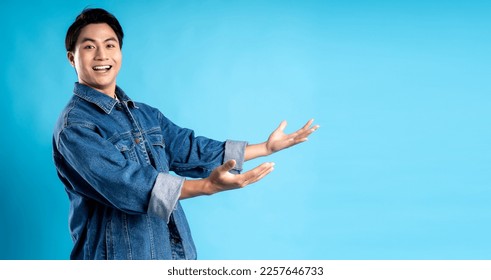  Young asian man posing on a blue background
 - Powered by Shutterstock