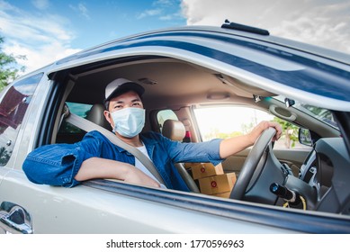 A Young Asian Man Is A Professional Driving A Package Delivery Car. Wear A Medical Mask Asians Work To Drive Online Deliveries To Home. There Is A Parcel Box In The Car.