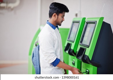 Young Asian Man Put His Credit Card For Removes Cash From An Green ATM.