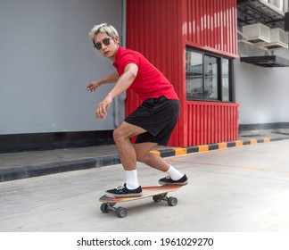 Young asian man riding skateboard on a city street. Male in t-shirt and black short pants surf skate exercising near sidewalk in urban. Skateboarding is trendy outdoor extreme sport through danger. - Powered by Shutterstock