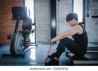 A Young Asian Man Is Sad And Disappointed. Sports Enthusiasts Sit On Polished Floors Or Epoxy Floors In The Gym To Overcome The Pressure Of Sports Concepts.