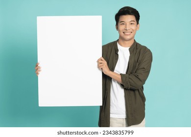 Young asian man showing and holding blank white billboard isolated on green background - Powered by Shutterstock