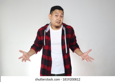 Young Asian Man With Shrug Shoulder Up Gesture, Showing I Don't Know Or Rejection, Over White Background