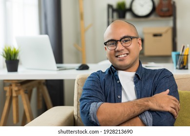 Young asian man Sit and relax in the living room on the sofa. He rested from work and smile.
