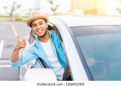 Young Asian Man Smiling And Showing Thumb Up In His Car.