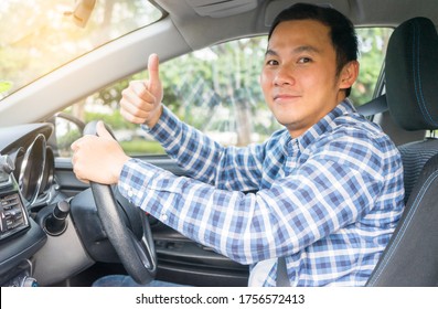 Young Asian Man Smiling And Showing Thumb Up In His Car. Travel Concept, Safety First Insurance Concept