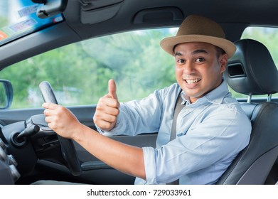 Young Asian Man Smiling And Showing Thumbs Up In Car