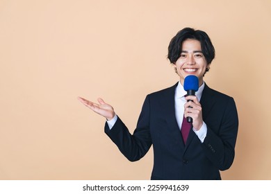 Young Asian man speaking with a microphone. - Powered by Shutterstock