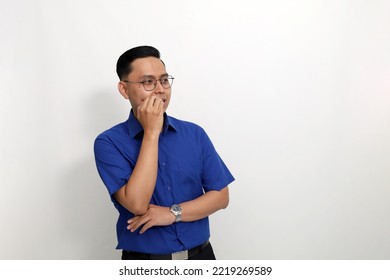 Young asian man standing while looking sideways at blank space. Isolated on white background with copyspace