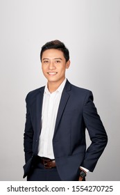 A Young Asian Man In Suit Put Both Hands In His Pants Pocket, Isolated On A White Background.