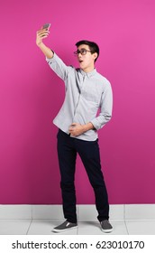 Young Asian Man Taking Selfie Near Color Wall