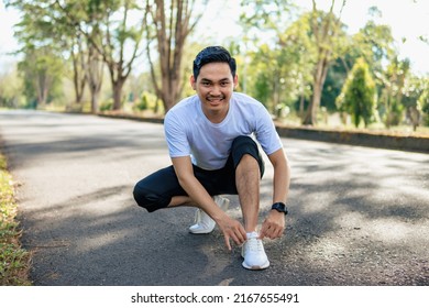 Young Asian man tying his shoes, preparing for running in the nature. Healthy lifestyle - Powered by Shutterstock