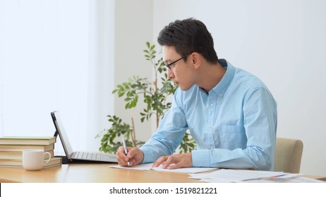 Young Asian Man Using Laptop For Study