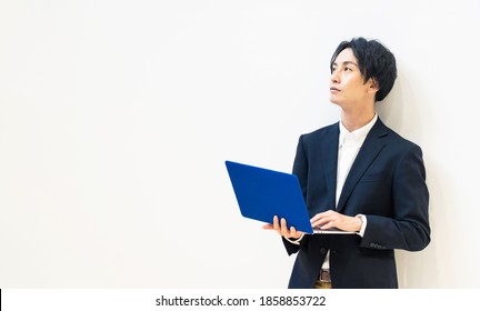 Young Asian Man Using A Laptop Pc.