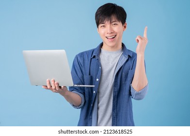 Young Asian Man Using Laptop On Blue Background