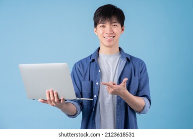 Young Asian Man Using Laptop On Blue Background