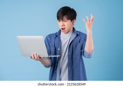 Young Asian Man Using Laptop On Blue Background