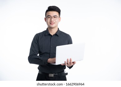 A Young Asian Man Is Using A Mobile Phone And Laptop