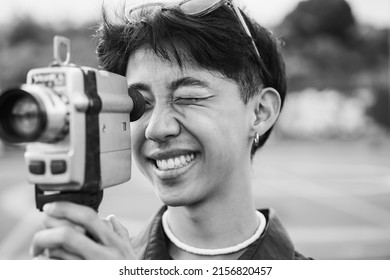 Young Asian Man Using Vintage Old Video Camera Outdoor - Focus On Right Eye - Black And White Editing