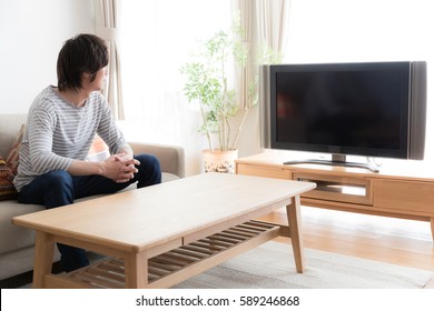 Young Asian Man Watching Tv In  The Living Room