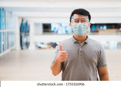 Young Asian Man Wear Face Shield And Mask Smiling In Shopping Mall