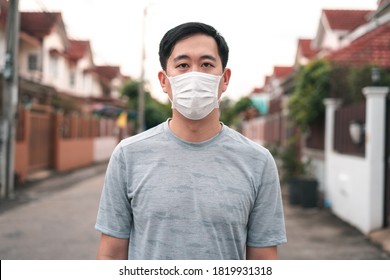 Young Asian Man Wearing A Face Protective Mask In Front Of His House Outdoors. Wearing A Face Mask Before Leaving Home.