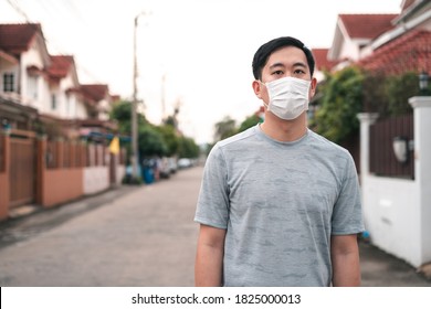 Young Asian Man Wearing A Face Protective Mask In Front Of His House Outdoors. Wearing A Face Mask Before Leaving Home.