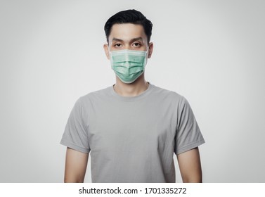Young Asian Man wearing hygienic mask to prevent infection, 2019-nCoV or coronavirus. Airborne respiratory illness such as pm 2.5 fighting and flu. Studio shot isolated on white background. - Shutterstock ID 1701335272