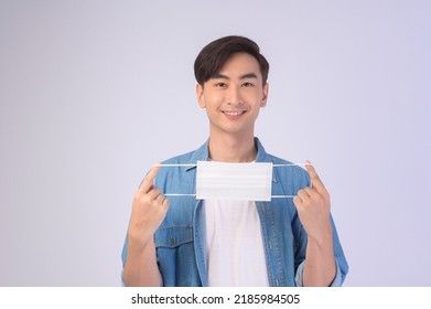 A Young Asian Man Wearing Protective Mask Over White Background Studio, Safety Travel , New Normal , Social Distancing , Covid19 And Pandemic Concept.