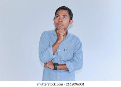 Young Asian Man Wearing Sky Blue Flannel Shirt Shows Thinking Movement