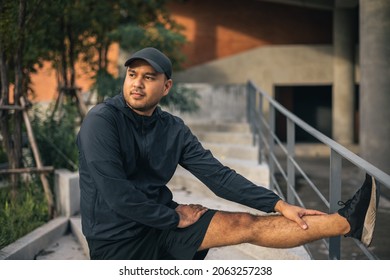 Young Asian Man Wearing Sportswear Running Outdoor. Portraits Of Indian Man Stretching Leg Before Running On The Road. Training Athlete Work Out At Outdoor Concept.