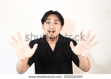 Young Asian man wearing t-shirt over isolated white background doing stop sign with palm.