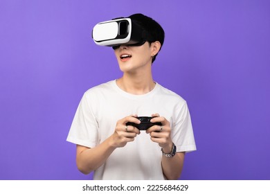 Young Asian man wearing VR headset enjoy playing video game  on futuristic purple cyberpunk.Man using VR headset while experiencing the virtual reality over an isolated background.  - Powered by Shutterstock