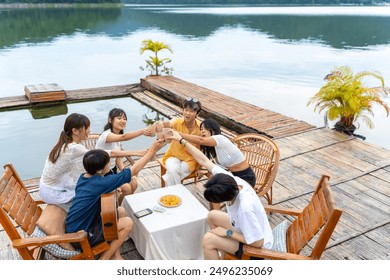 Young Asian man and woman enjoy outdoor lifestyle travel nature forest mountain on summer holiday vacation. Generation z people friends party playing guitar and singing together at lake house balcony. - Powered by Shutterstock