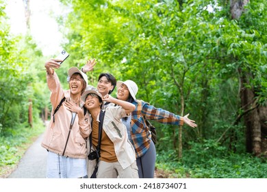 Young Asian man and woman friends travel nature on summer holiday vacation. Happy people enjoy and fun outdoor lifestyle using mobile phone taking selfie or vlogging together at forest mountain. - Powered by Shutterstock