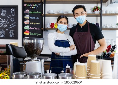 Young Asian man and woman wearing face mask to work in coffee shop after lockdown. Business adjust after COVID-19 Breakout to protect pandemic. Communicable disease is cause of business interruption. - Powered by Shutterstock