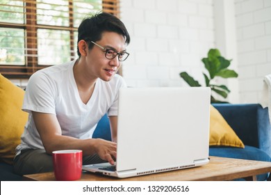 Young Asian Man Working With Laptop At Home