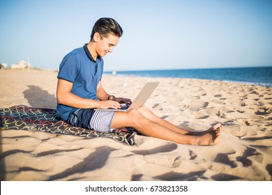 Young Asian Man Working With Laptop Computer On Tropical Beach 