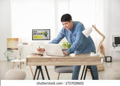 Young Asian Man Working On Laptop At Home