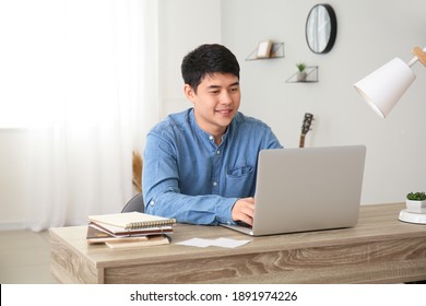 Young Asian Man Working On Laptop At Home